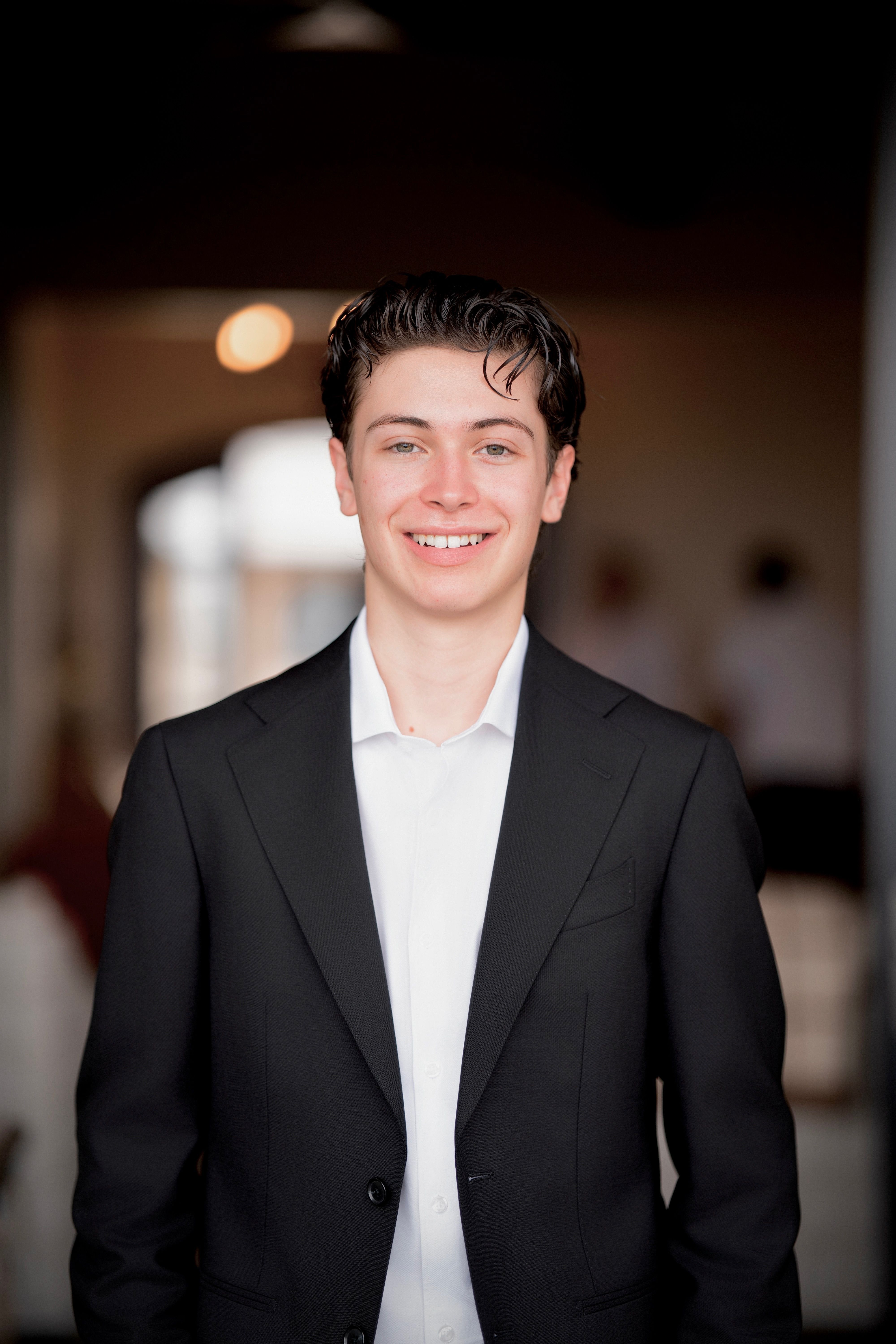 Santiago Carbone, smiling, in a dark blazer and white shirt